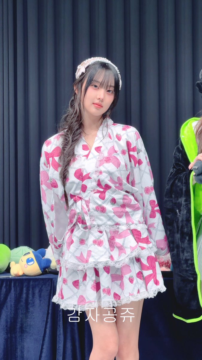 A woman wearing a pink and white strawberry-patterned outfit and a lace headband poses in front of a dark curtain, with Korean text '감자콩주' at the bottom.
