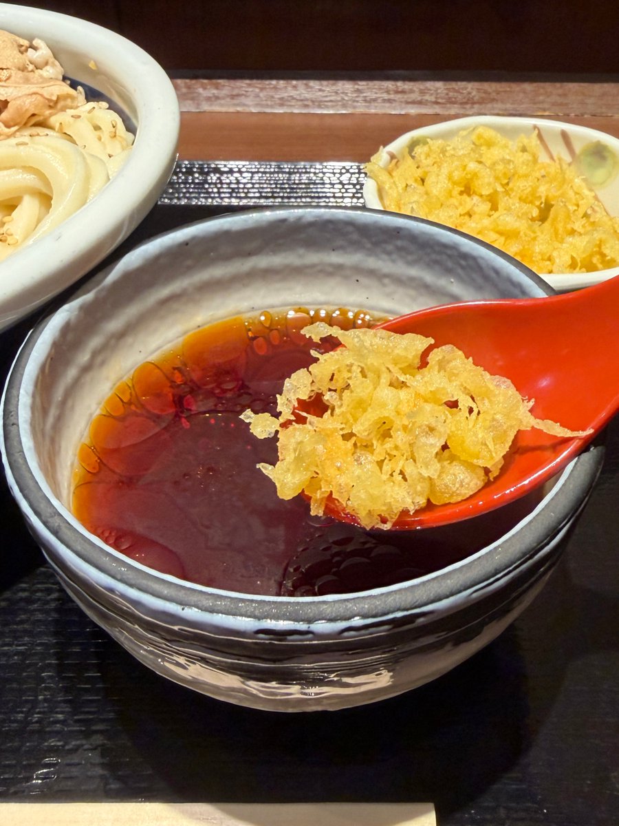 UdonMarugame's tweet photo. #旨辛豚つけ汁うどん が明日から定番商品に✨
打ち立てうどん3玉まで同一価格なので、薬味を加えながら味わいを変えて楽しむのもおすすめです！

しび辛ラー油のしびれる辛さや、天かすのサクサクとした食感とコクをプラス。
途中で少しずつ加えて、お好みの味わいを見つけてみてください♪#丸亀製麺 https://t.co/ezAIy9DGKw