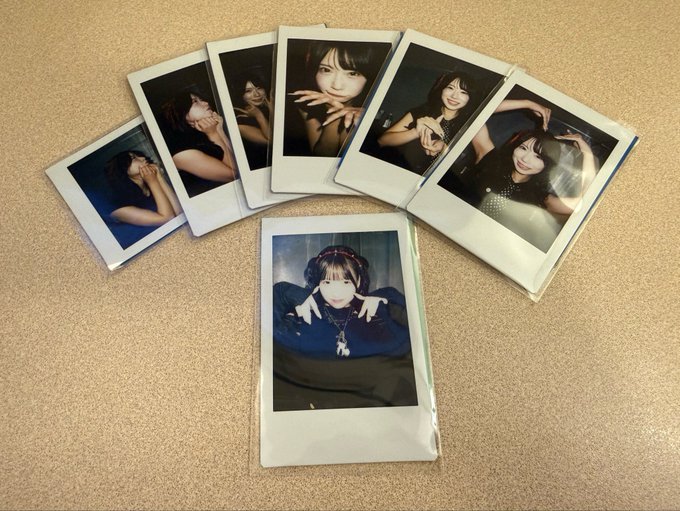 Seven polaroid photographs fanned out on a corkboard, displaying various portraits of a young woman in different poses and outfits.