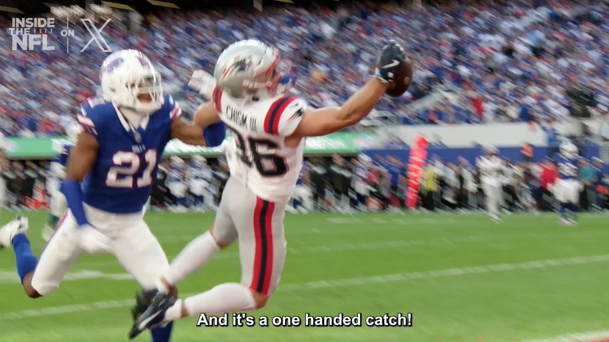 A New England Patriots player wearing jersey #15 makes a spectacular one-handed catch against a Buffalo Bills defender wearing #21, with the caption "And it's a one handed catch!" displayed on screen. The "Inside the NFL" logo appears in the top left corner, matching the post about Vrabel and the Patriots sideline's reaction to Chism's impressive grab.