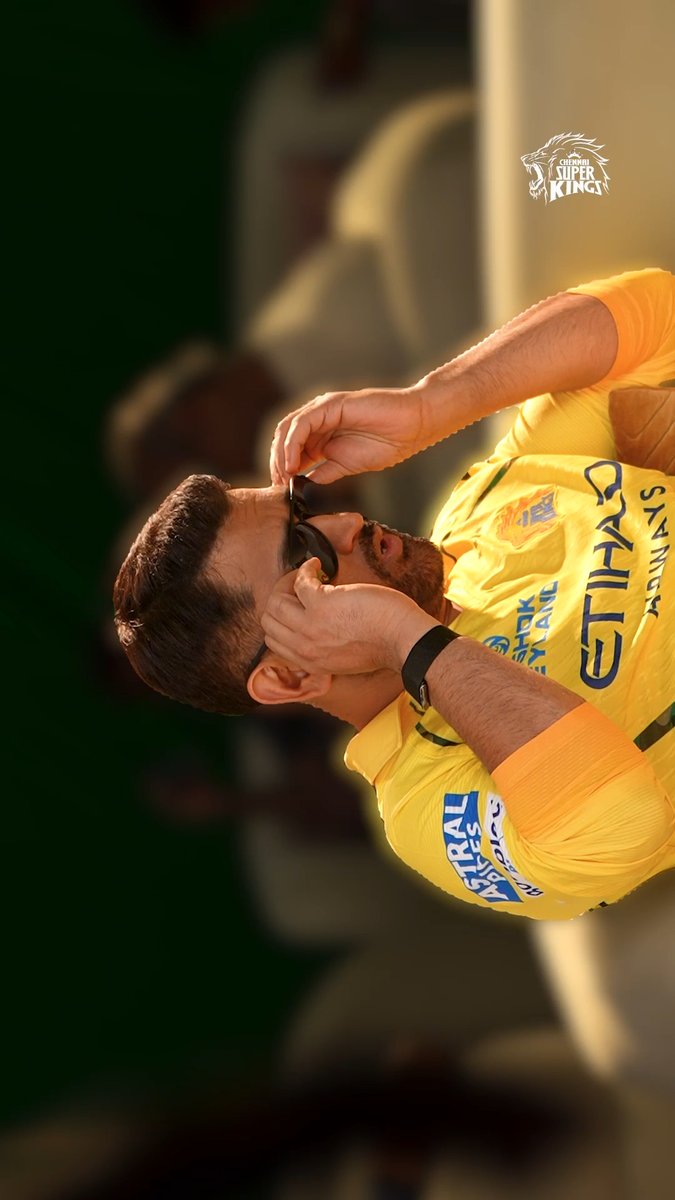 A cricket player in a yellow Chennai Super Kings jersey adjusts his sunglasses, with the 'Chennai Super Kings' lion logo visible in the upper right corner.