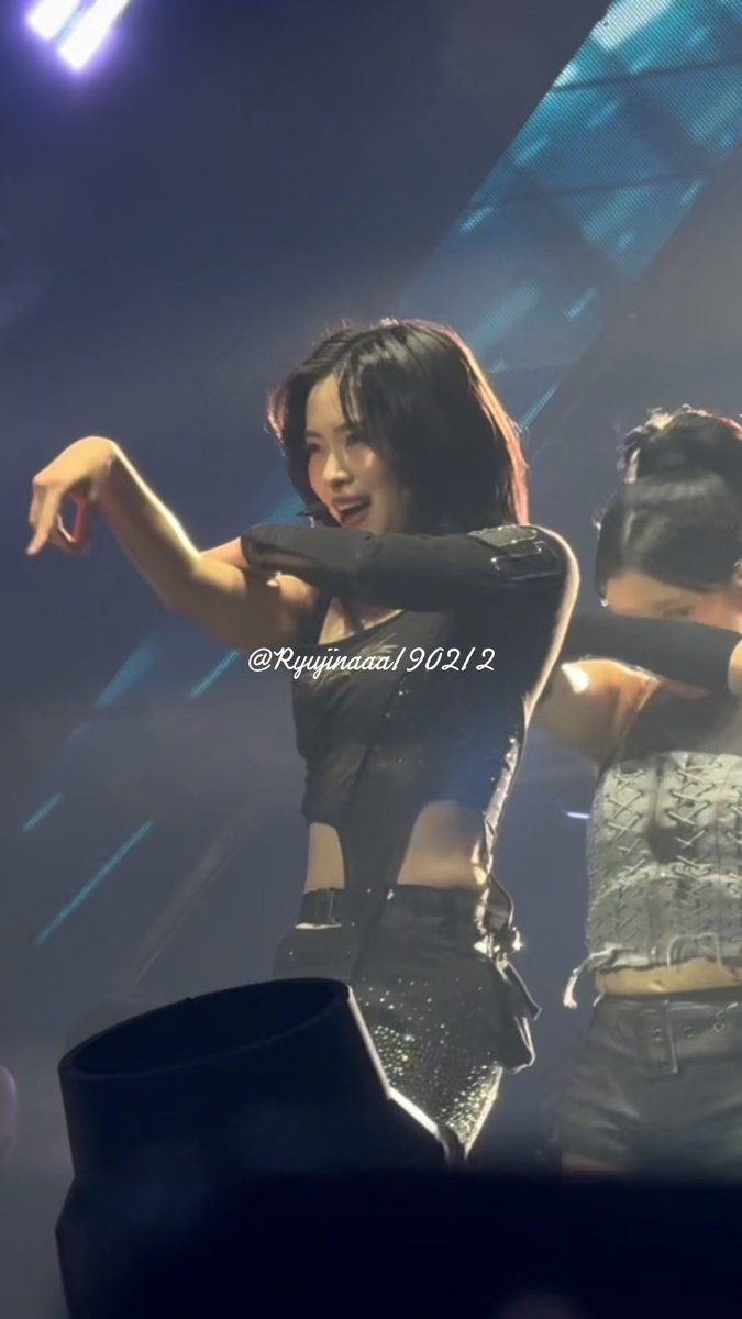 A concert photo of a female performer in a black corset-style top dancing on stage, with the watermark '@Ryujindaa190212' visible in the middle of the image.