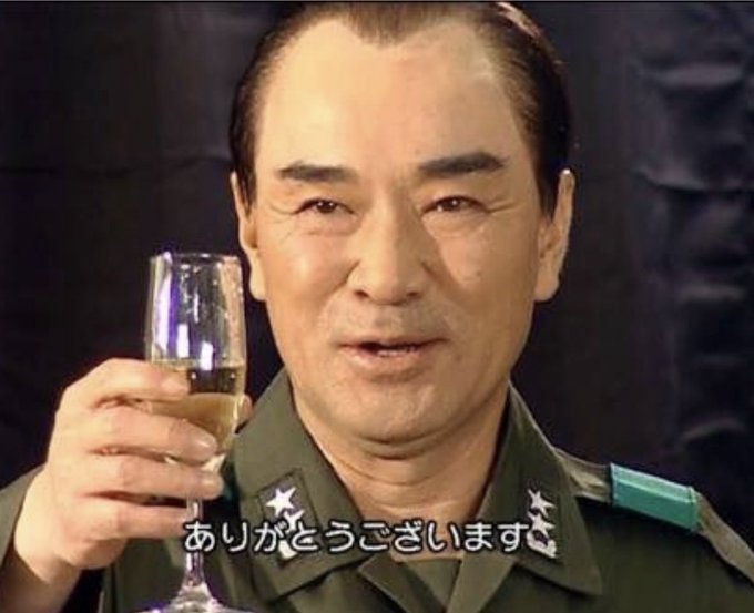 A man in a military uniform with star insignia raises a glass in a toast, with Japanese subtitles 'ありがとうございます' (Thank you very much) displayed at the bottom.