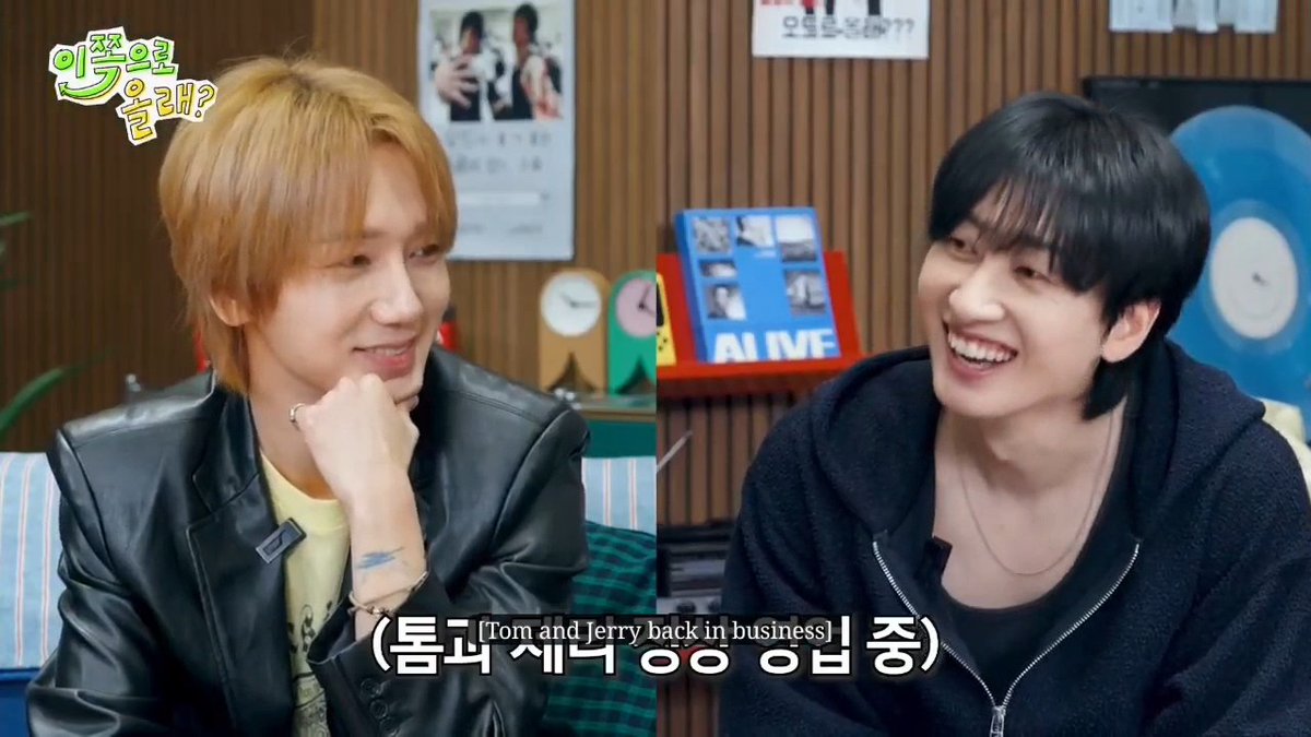 Two Korean men laugh together on a talk show set, with one sporting blonde hair and a leather jacket; Korean subtitles read '(톰과 제리 흥업 중)' (Tom and Jerry back in business).