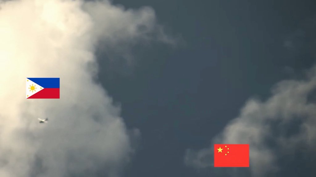 A cloudy sky scene with the Philippine flag on the left and the Chinese flag on the right, suggesting geopolitical tension between the two nations.