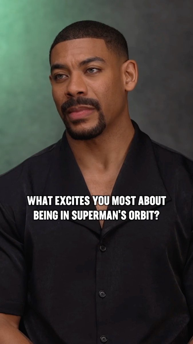 Aaron Pierre appears in an interview setting wearing a black shirt, with on-screen text asking "What excites you most about being in Superman's orbit?" — directly tying into the accompanying post about his role as John Stewart in the #Lanterns series, where he works alongside Superman to tackle universe-level threats.