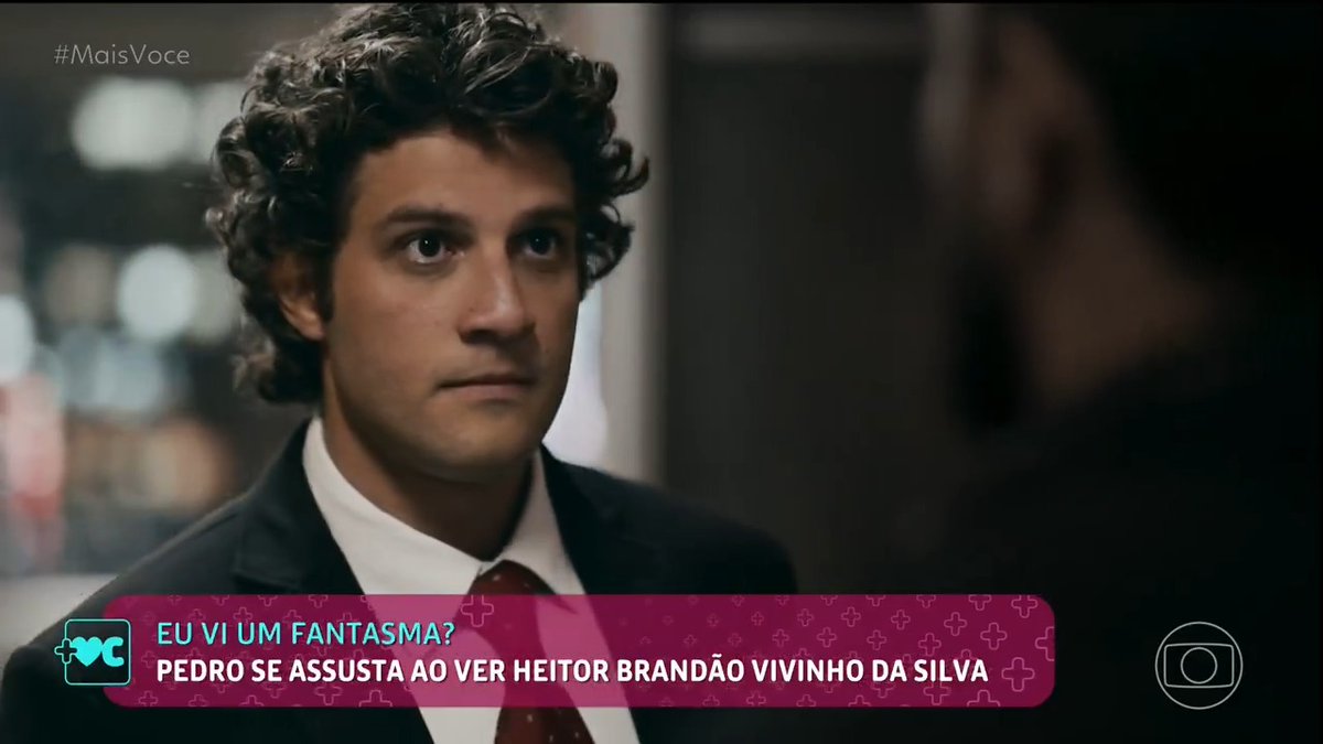 A screenshot from the Brazilian telenovela '#MaisVoce' showing a curly-haired man in a suit with text reading 'EU VI UM FANTASMA? PEDRO SE ASSUSTA AO VER HEITOR BRANDÃO VIVINHO DA SILVA'.