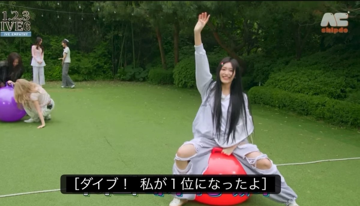 A Japanese TV program scene from '1.2.3 IVE6' showing a young woman in gray sitting on a red spacehopper, with another person on a purple one nearby; Japanese subtitles read '[ダイブ！私が1位になったよ]'.
