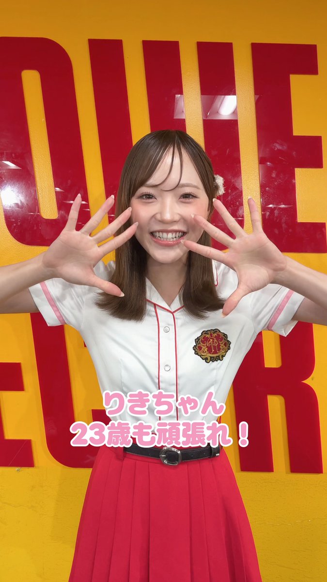 A smiling young woman in a white and red uniform with a crest poses with her hands up in front of a yellow 'QUEEN'S BURGER' sign, with Japanese text 'りきちゃん 23歳も頑張れ！' overlaid.