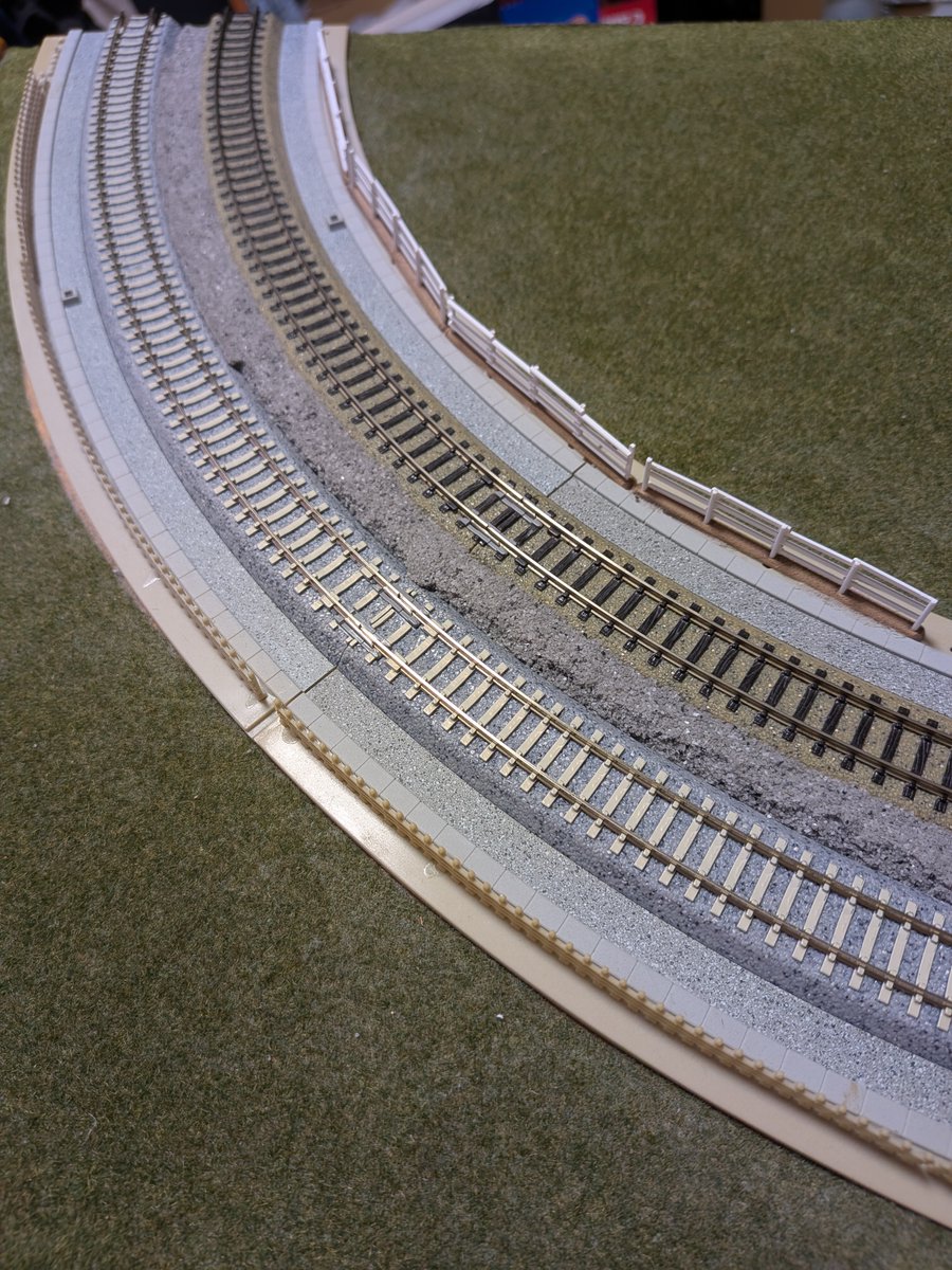 IchiroYqz01403's tweet photo. KATOユニトラック複線プレート曲線線路を使用して作成したT-TRAKコーナーモジュール。
既に20年以上使用してきましたが、接続部道床が破損したのと、来月のイベントで使用するために、最近発売された「PCまくらぎ単線線路」
に線路交換しました。
プレートと線路はネジ2本で固定しているのですが、
新しい線路とネジ穴位置は同一なので、問題なく交換出来ました。この後内側も交換します。
なお、T-TRAKではカント無しの方が良いです。