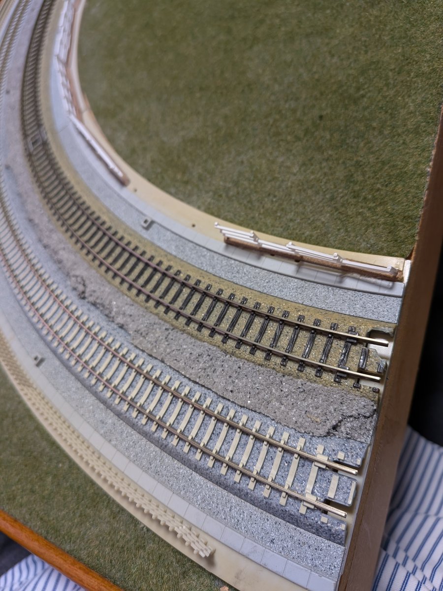 IchiroYqz01403's tweet photo. KATOユニトラック複線プレート曲線線路を使用して作成したT-TRAKコーナーモジュール。
既に20年以上使用してきましたが、接続部道床が破損したのと、来月のイベントで使用するために、最近発売された「PCまくらぎ単線線路」
に線路交換しました。
プレートと線路はネジ2本で固定しているのですが、
新しい線路とネジ穴位置は同一なので、問題なく交換出来ました。この後内側も交換します。
なお、T-TRAKではカント無しの方が良いです。