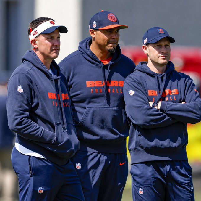 Three Chicago Bears coaches or staff members wearing navy blue Bears Football hoodies and caps on a field.