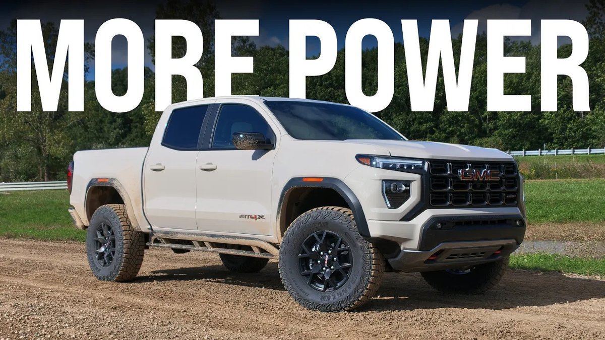 A white 2027 GMC Canyon AT4X pickup truck is parked on a dirt path with bold white text reading "MORE POWER" overlaid at the top of the image, directly referencing the post's claim about the truck's performance improvements compared to the Toyota Tacoma.
