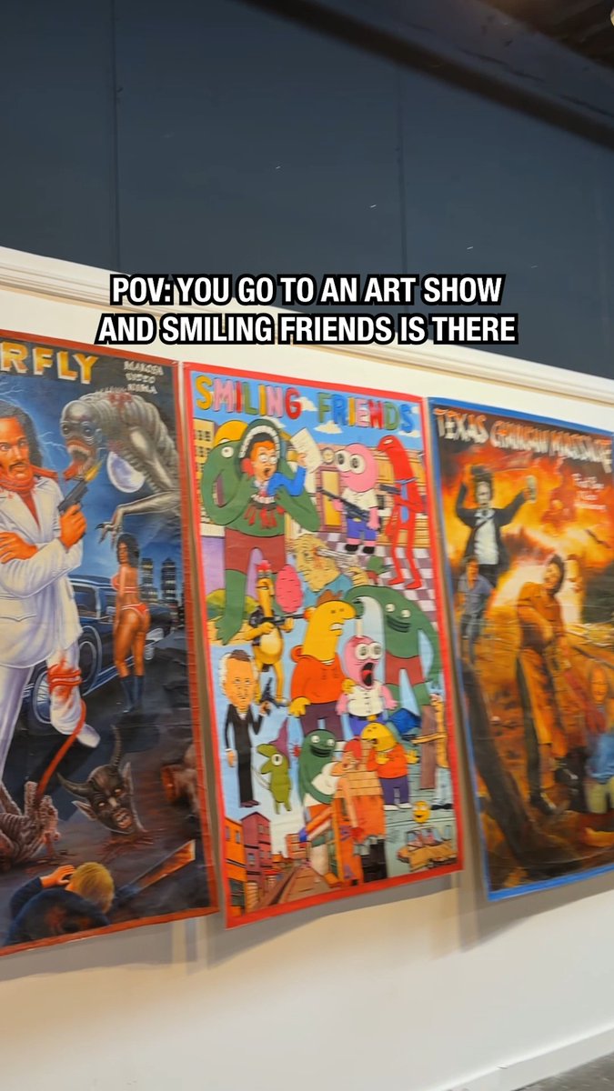 A "Smiling Friends" artwork displayed alongside "Firefly" and "Texas Chainsaw Massacre" posters at an art show, featuring the show's colorful characters against a city backdrop. The post praises the vibrant painting as a collaboration between Ghanaian artist Heavy J and Deadly Prey Gallery, highlighting its place among other pop culture-inspired art pieces.