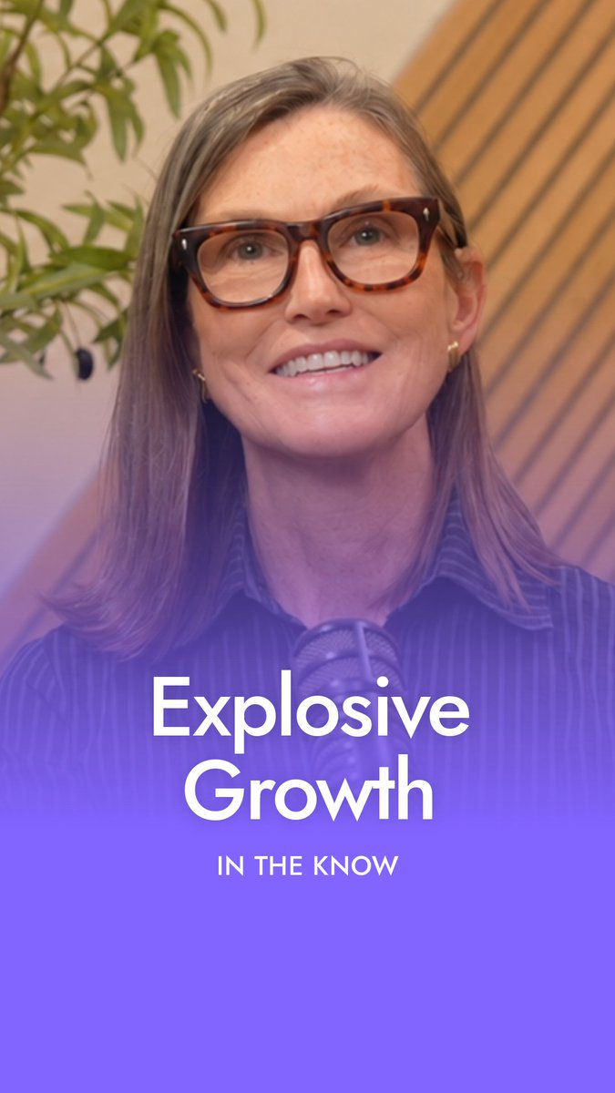 A smiling woman with tortoiseshell glasses speaks into a microphone in front of a green plant, with bold white text reading "Explosive Growth" and "IN THE KNOW" overlaid on a purple background, promoting Cathie Wood's October segment explaining how falling AI costs are driving OpenAI's revenue surge from $20B to $70B.