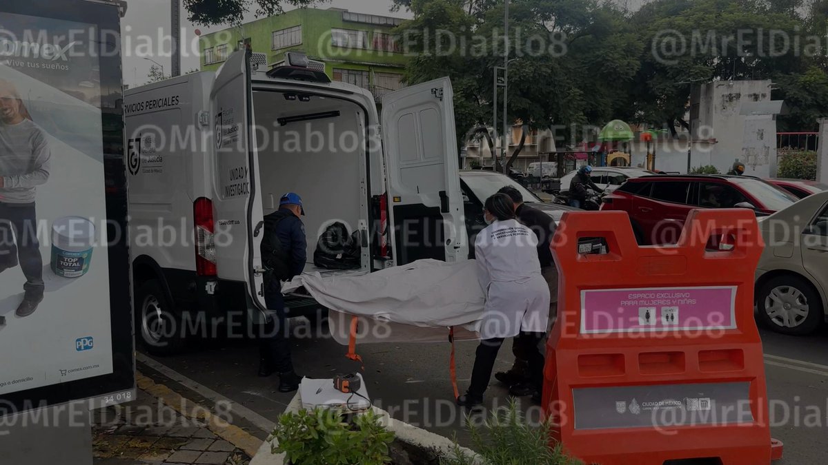 Forensic investigators in white coats and a police officer load a body on a stretcher into a Servicios Periciales van, with the image watermarked '@MrElDiablo8'.