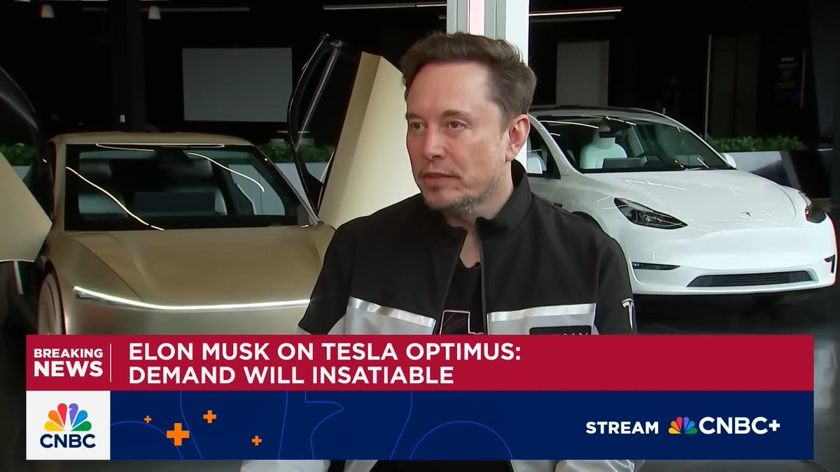 A CNBC news broadcast screenshot showing Elon Musk with the headline 'BREAKING NEWS: ELON MUSK ON TESLA OPTIMUS: DEMAND WILL INSATIABLE,' featuring a gold and a white Tesla vehicle in the background.
