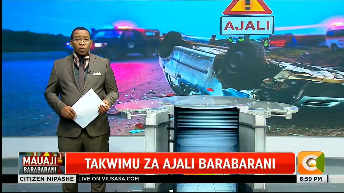 A male news presenter stands in a studio with a large screen behind him displaying an overturned vehicle at an accident scene marked "AJALI," while the lower ticker reads "MAUAJI BARABARANI," "TAKWIMU ZA AJALI BARABARANI," and "CITIZEN NIPASHE LIVE ON VIUSASA.COM" at 6:59 PM, supporting the post's topic of road accident statistics.