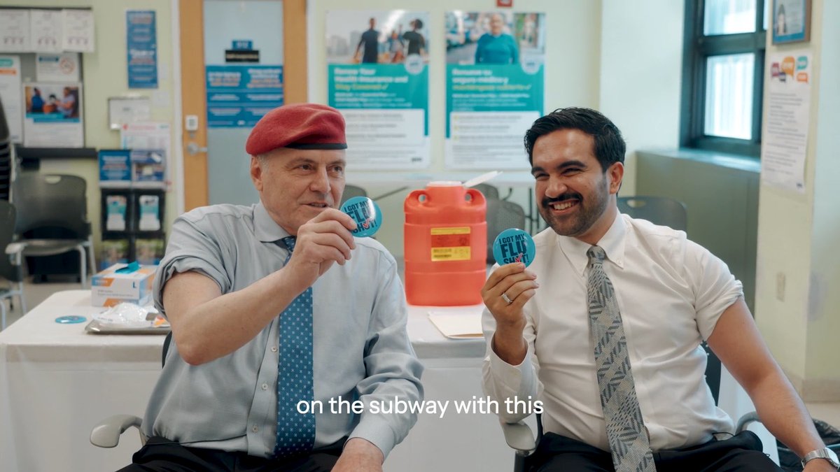 Two men in shirts and ties sit in a medical clinic holding 'I Got My Flu Shot' stickers, with the text 'on the subway with this' appearing at the bottom.