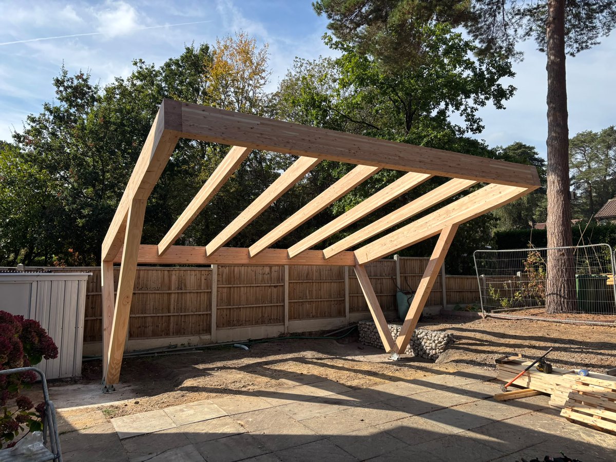 BucklandTimber's tweet photo. This glulam car port is now up on site, with its angled posts and roof beams forming the main structure. A nice example of #glulam being used on a relatively small project - will be good to see this one again once the roof is complete with solar panels. https://t.co/GXRacl5z64