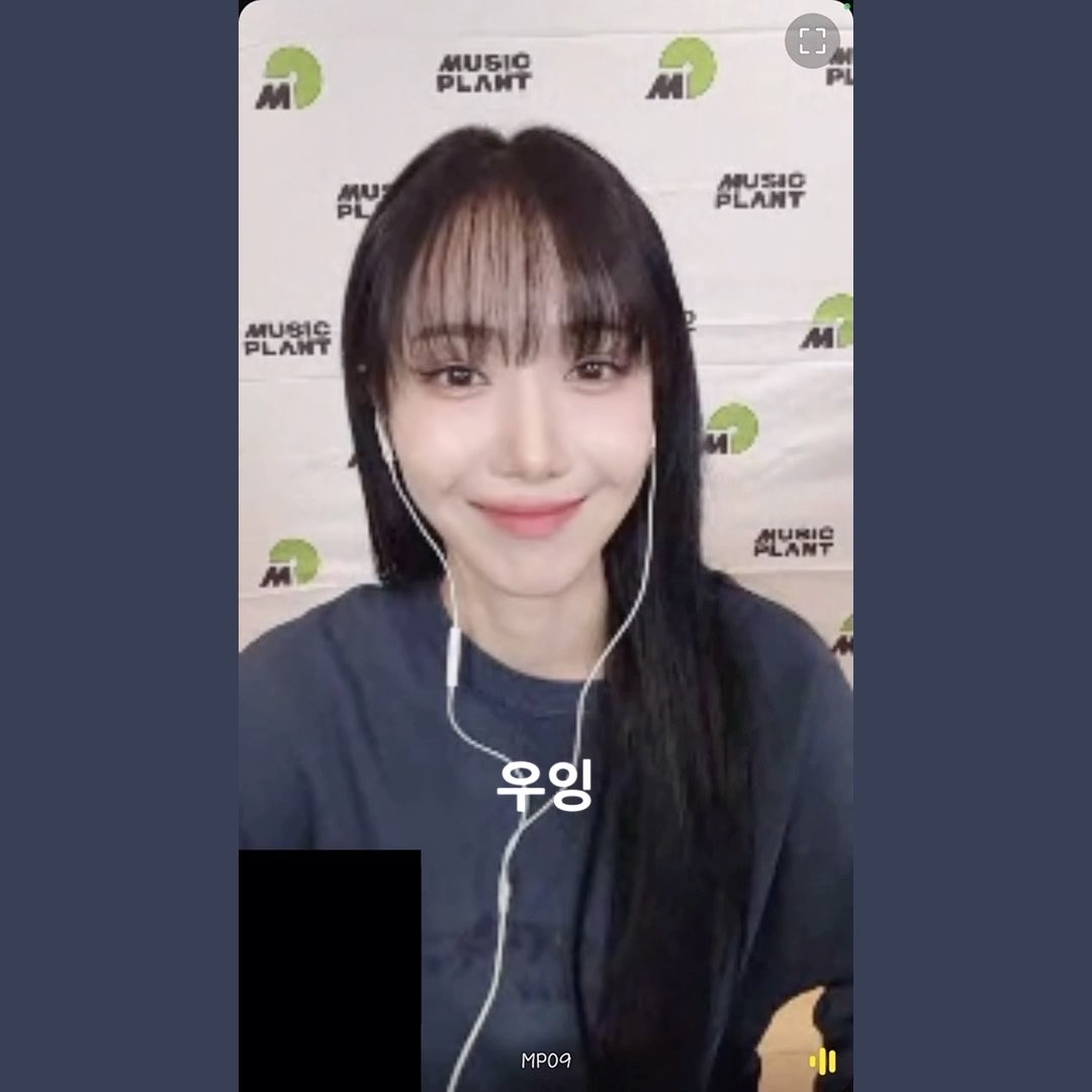 Screenshot from a 'MUSIC PLANT' video call showing a young woman with long dark hair and earphones smiling, with Korean text '우잉' overlaid on the image.