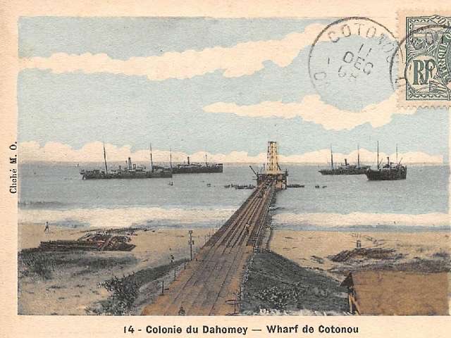 dan_p_ofem's tweet photo. How a Metal Bridge Changed Cotonou

In 1908, the town of Cotonou in Dahomey opened a big metal wharf. This structure went straight out into the sea.

Before it was built, moving goods was difficult. 
Big ships could not come near the beach because the water was too shallow. 

The ships stopped far out in the deep water. Workers used small boats to carry barrels of palm oil, boxes, and people to the beach. 

The ocean waves often flipped the boats. Many things fell into the water and were lost. The work was highly dangerous.

The new metal wharf changed everything. It acted as a bridge over the rough coastal waters.

The big ships still anchored far out in the sea. However, workers now rowed flat boats from the ships directly to the end of the wharf. 
They no longer had to fight the dangerous waves near the shore. At the end of the wharf, a big crane lifted the heavy barrels out of the boats. 
Workers then moved the goods safely to land with dry feet.

By 1908, the wharf was very busy. The courtyard was full of big barrels of palm oil, which was Dahomey's main export. Men rolled the barrels, clerks wrote in notebooks, and small trains moved along the tracks.

The wharf made life safer for the workers and made business faster for the town. 
More goods left Cotonou safely for Europe.

That old metal wharf is gone now, but it was the start of something big. 
In 1964, it was replaced by a huge modern port called the Port Autonome de Cotonou. 
The 1908 wharf was simple, but it turned a dangerous beach into a real trading city.