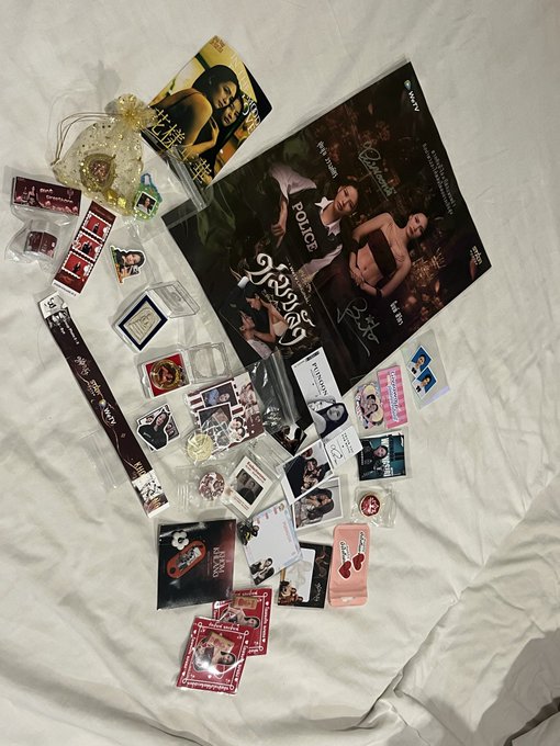 A collection of K-pop merchandise, including photocards, stickers, and accessories related to Stray Kids' 3RACHA and other groups, scattered on a white bedsheet.