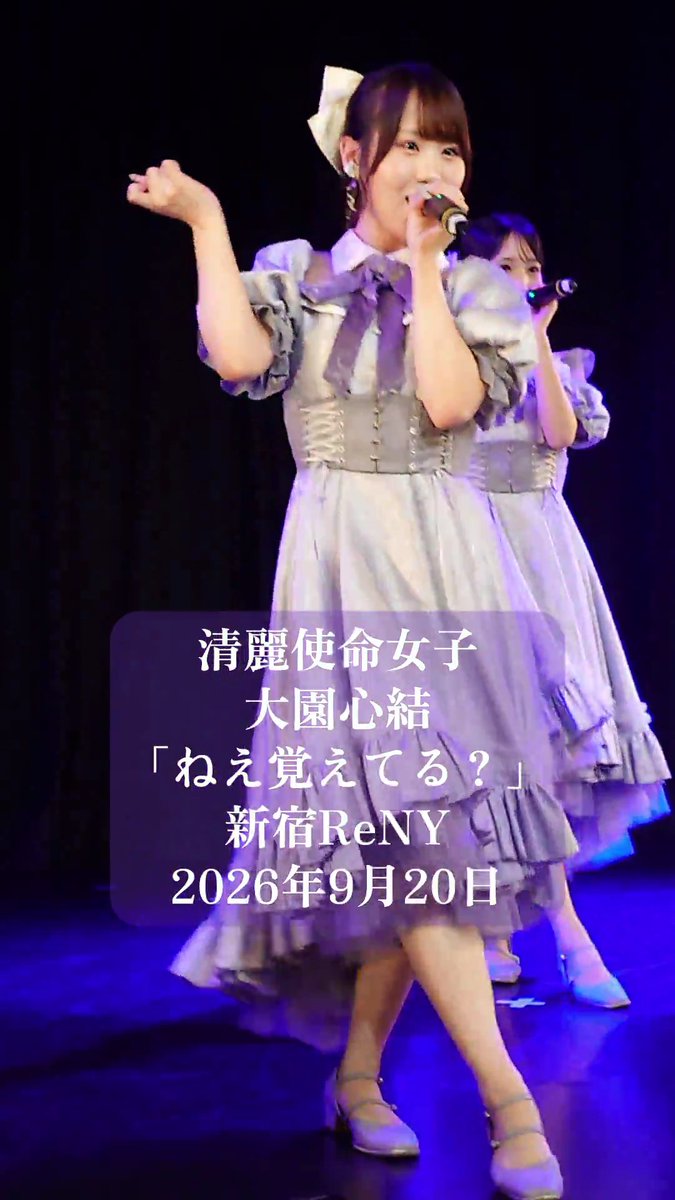 A young Japanese female performer singing into a microphone on stage, wearing a frilly gray and white dress with a purple bow; Japanese text on the image reads '清麗使命女子 大園心結「ねえ覚えてる？」 新宿ReNY 2026年9月20日'.