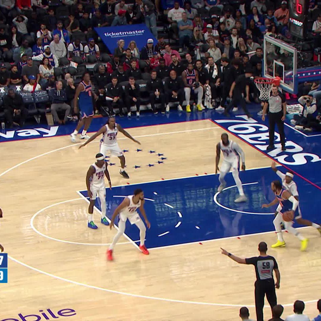 A Philadelphia 76ers player in a white jersey with "76ers" branding guards the painted area while a Philadelphia 76ers player in a blue jersey appears to be shooting or passing near the basket, with "ticketmaster" signage and a shot clock reading "16" visible in the arena.

The image relates to the post by highlighting a shooting moment, likely referencing KAT's scoring ability from that game.