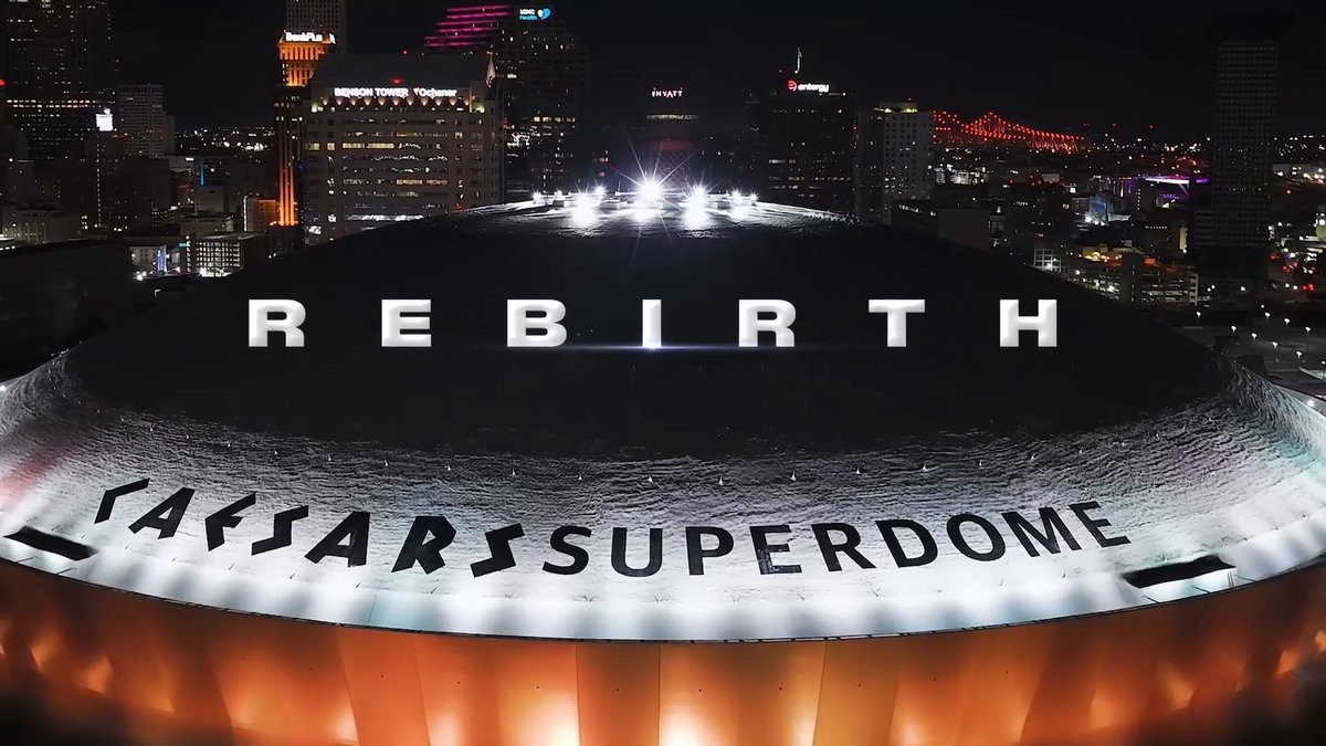 The image shows the Caesars Superdome illuminated at night with "REBIRTH" projected across its roof and "CAESARS SUPERDOME" emblazoned on its exterior, set against the New Orleans skyline. This visual ties directly to the post's theme of resilience and renewal, capturing the iconic symbol of the city's recovery and enduring spirit two decades after Hurricane Katrina.