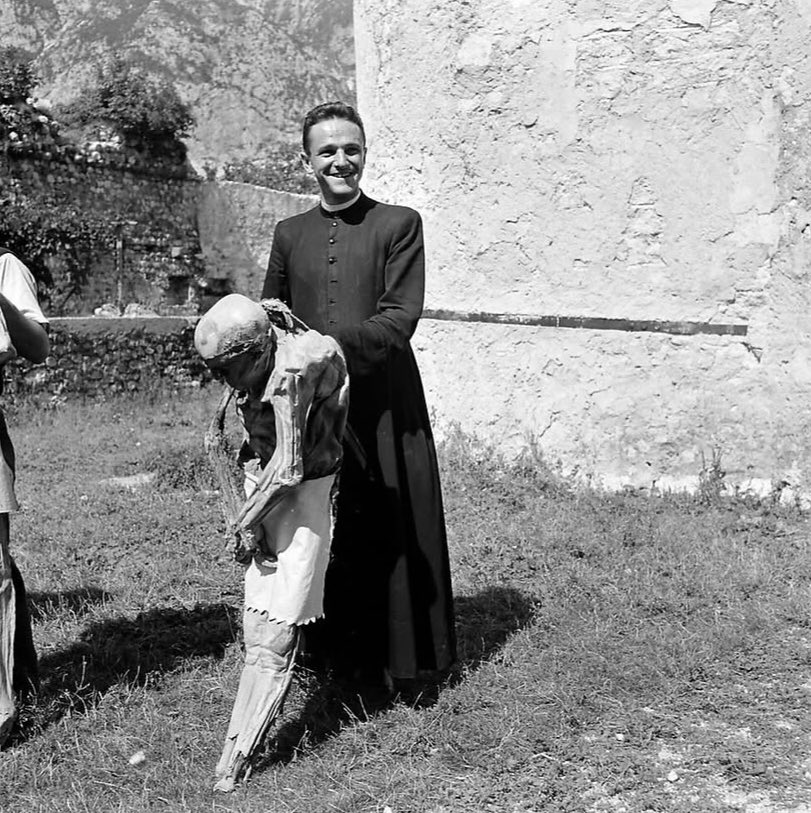 sonnysehra's tweet photo. in 1950, a photographer lost in the alps needed a place to stay for the night and found a rural italian commune, where he saw an old man drinking tea with a mummy. the corpses were from the plague, locals believing it was god’s will for their ancestors to protect the village. https://t.co/TLInAiM8Go