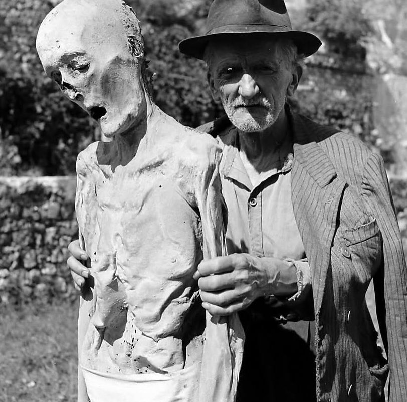 sonnysehra's tweet photo. in 1950, a photographer lost in the alps needed a place to stay for the night and found a rural italian commune, where he saw an old man drinking tea with a mummy. the corpses were from the plague, locals believing it was god’s will for their ancestors to protect the village. https://t.co/TLInAiM8Go