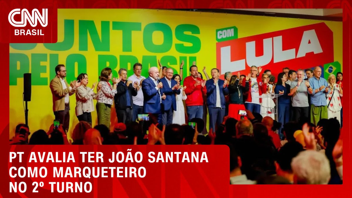 A CNN Brasil news broadcast shows a large group of people on stage at a campaign event with banners reading "JUNTOS PELO BRASIL" and "COM LULA" in yellow, green, and red. A red news ticker at the bottom reads "PT AVALIA TER JOÃO SANTANA COMO MARQUETEIRO NO 2º TURNO," corresponding to the accompanying post about the Workers' Party evaluating João Santana as their marketer for the second round of elections.