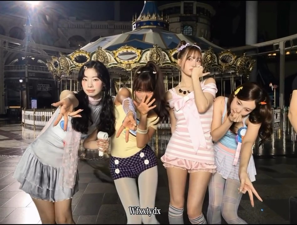 Four young women in colorful, pastel-themed outfits pose together in front of a lit-up carousel at night, with a 'Wixxtydx' watermark at the bottom.