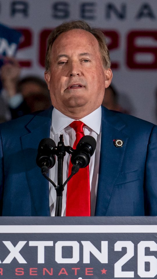 Texas Attorney General and Republican Senate candidate Ken Paxton speaks at a campaign rally, with signage reading "Paxton 26" and "Senate" visible behind and beneath his podium as he addresses supporters. The image relates to the post's claim that Paxton is attempting to distance himself from former President Trump ahead of his Senate bid.