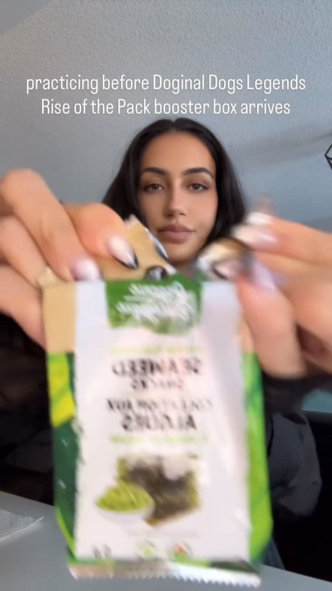 A woman holding a bag of seaweed snacks toward the camera, with text reading 'practicing before Doginal Dogs Legends Rise of the Pack booster box arrives'.