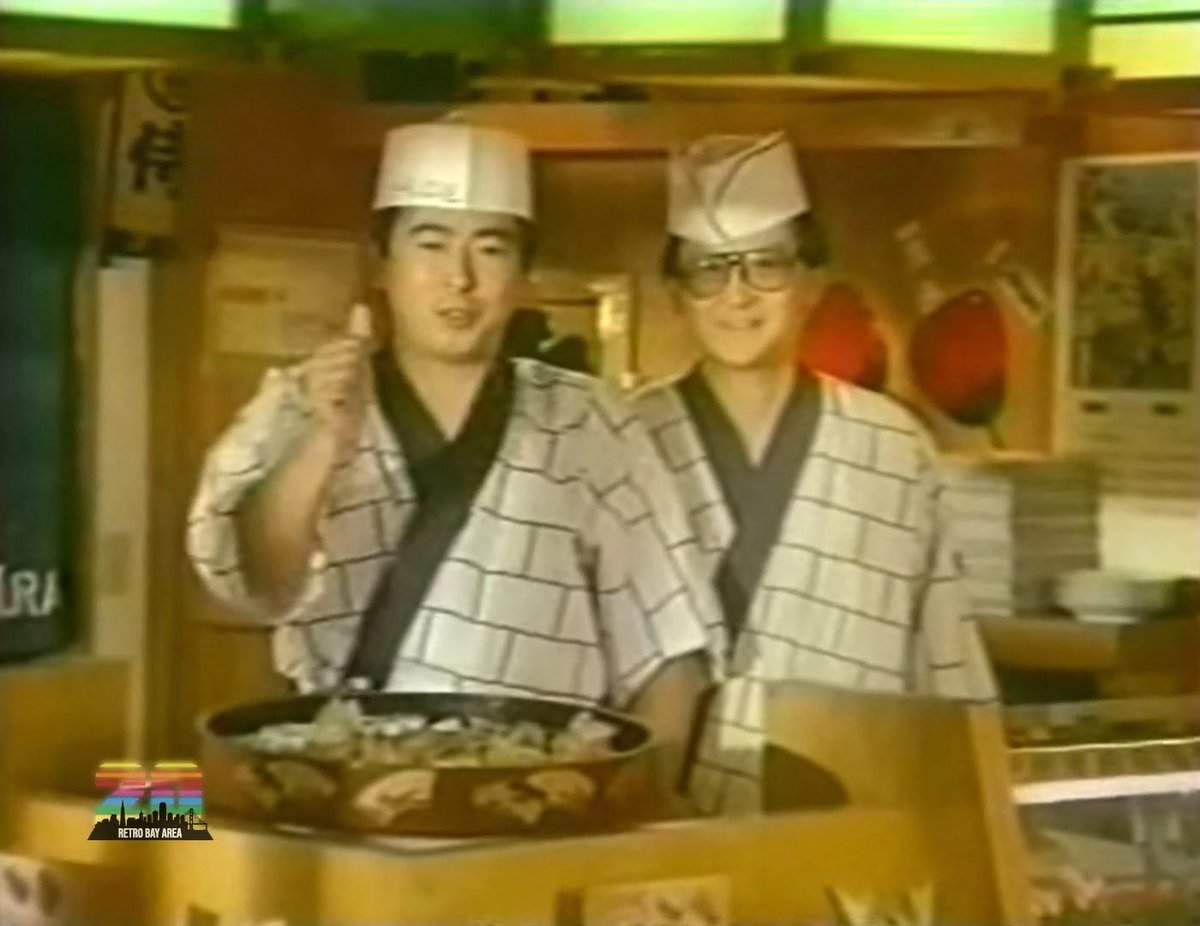 Two men in traditional Japanese chef attire, including white caps and patterned jackets, stand behind a counter with a large bowl of food, likely in a vintage film clip related to a movie being featured at the 1985 Mill Valley Film Festival. The "Retro Bay Area" logo appears in the bottom left corner.