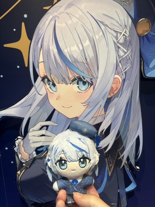 An anime-style illustration of a silver-haired girl with blue accents holding a plush toy version of herself, set against a starry background.