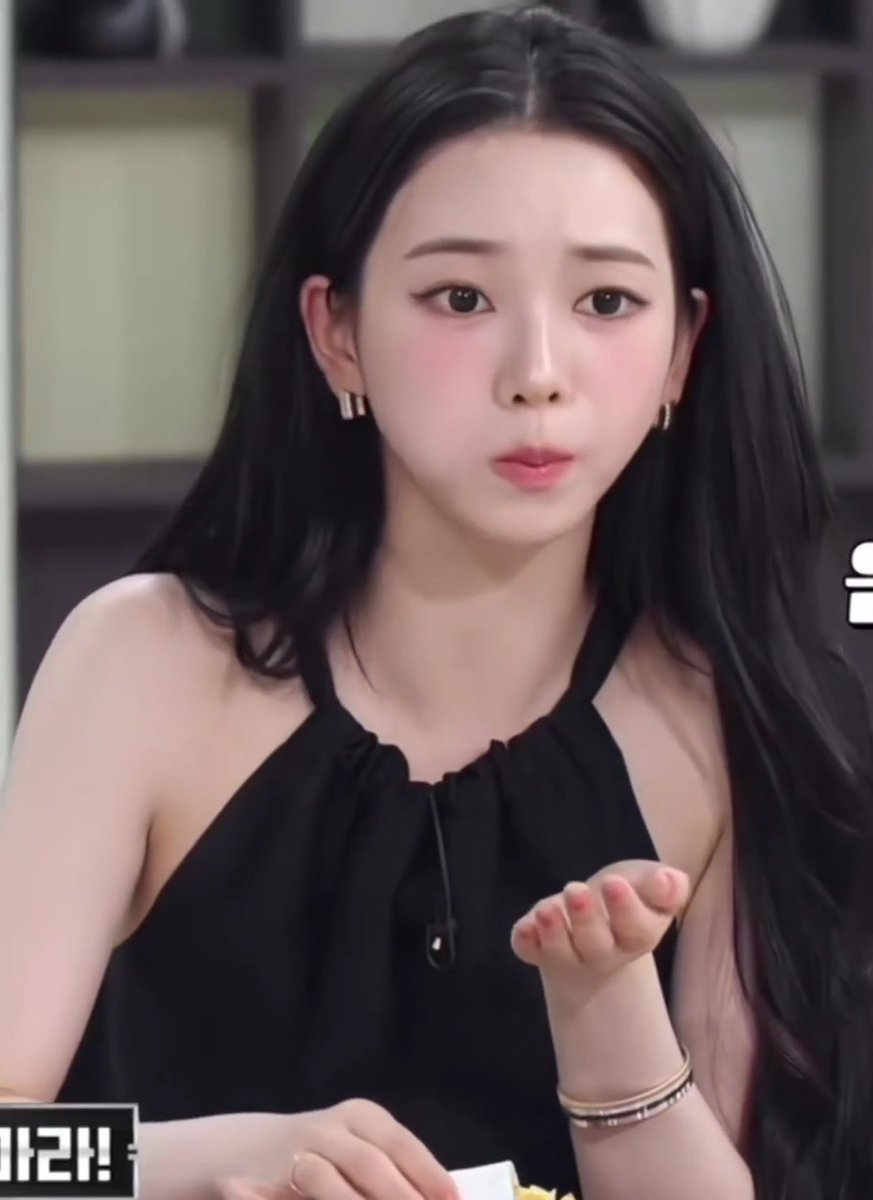 A young woman with long black hair wearing a black halter top blows a kiss toward the camera, with Korean text '가라!' visible in the corner.