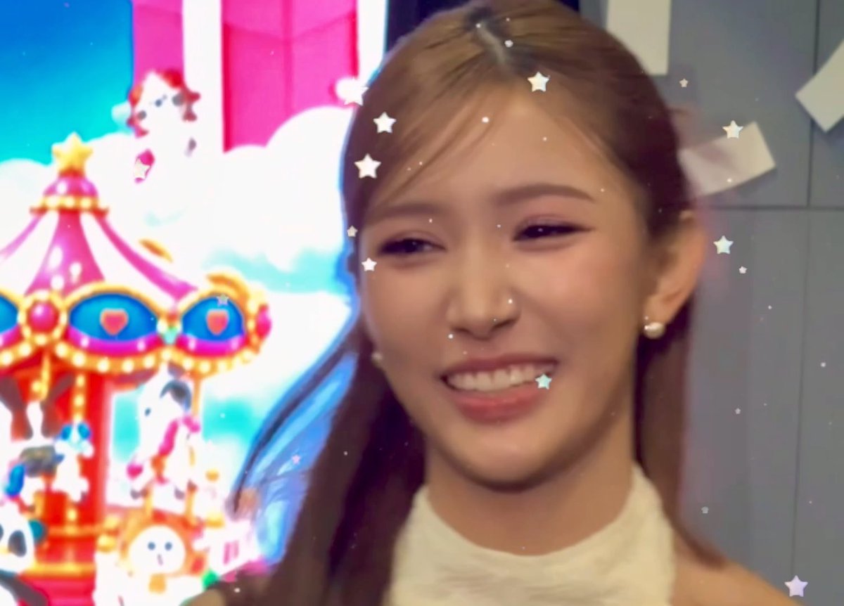 A smiling woman with long brown hair is shown in front of a colorful carousel backdrop, with a star-shaped digital filter overlaying the image.