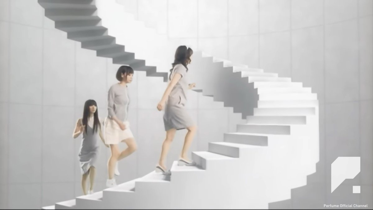 Three women in matching gray dresses walk up a stark white staircase in a minimalist white room, a scene from a music video credited to "Perfume Official Channel" in the bottom corner.