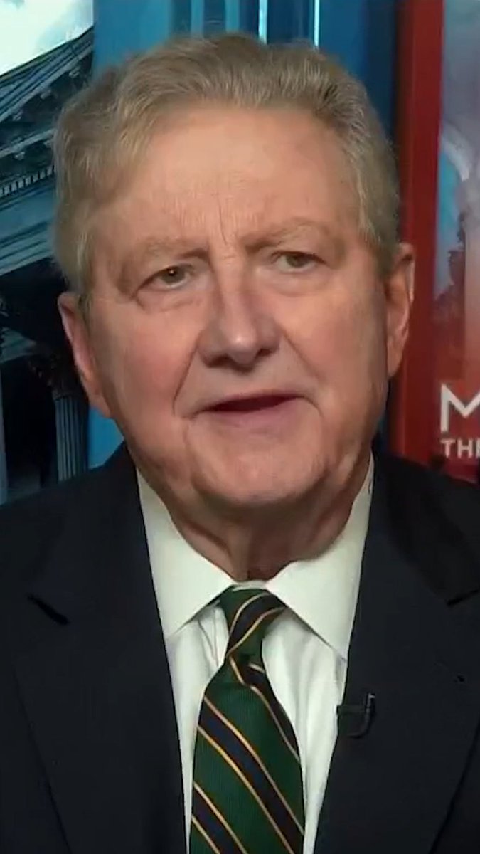 A man in a dark suit with a green striped tie speaks during a televised interview, with partial text "M... THE..." visible on a red backdrop behind him. The post "Got him." suggests a victorious moment, possibly referencing this broadcast or the speaker as a target of capture or criticism.