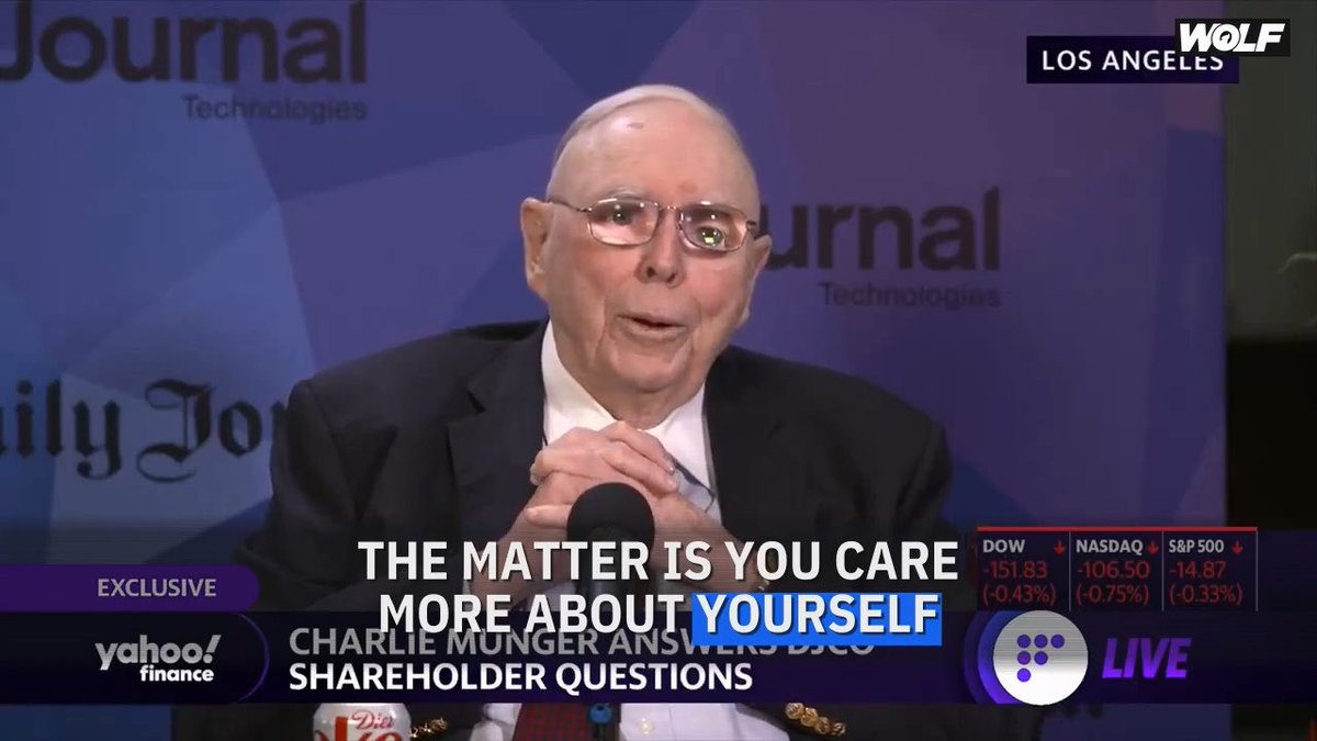 A Yahoo Finance exclusive interview broadcast from Los Angeles featuring Charlie Munger speaking at a Daily Journal Technologies event, with on-screen text reading "THE MATTER IS YOU CARE MORE ABOUT YOURSELF" and "CHARLIE MUNGER ANSWERS DJCO SHAREHOLDER QUESTIONS"; stock tickers show DOW, NASDAQ, and S&P 500 all down.