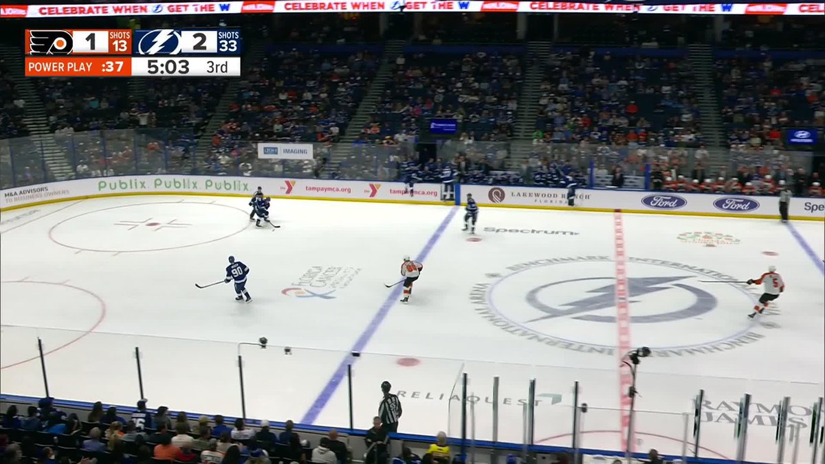 A hockey game in progress between the Philadelphia Flyers and Tampa Bay Lightning, with the scoreboard showing the Flyers losing 1-2 during a power play late in the 3rd period.