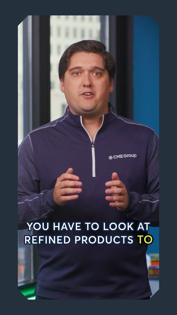 A man in a navy CME Group quarter-zip pullover stands in an office speaking, with the on-screen caption reading 'YOU HAVE TO LOOK AT REFINED PRODUCTS TO'.