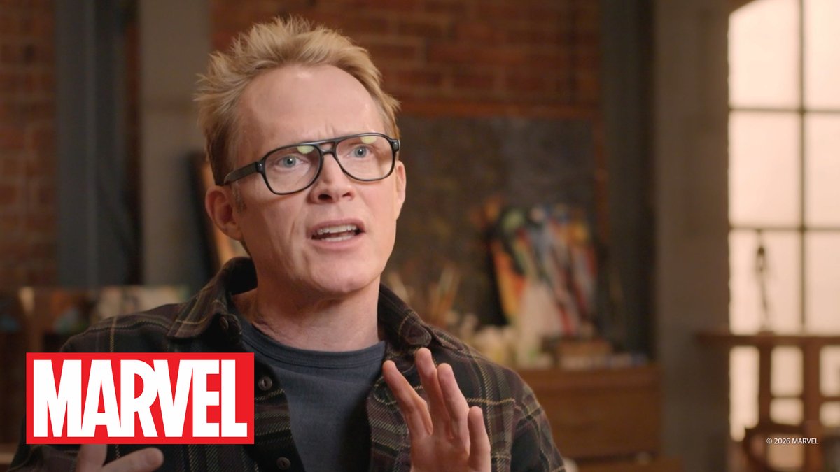 A man with blonde hair and glasses wearing a plaid shirt speaks in an interview setting with a 'MARVEL' logo and '© 2026 MARVEL' watermark in the corner.
