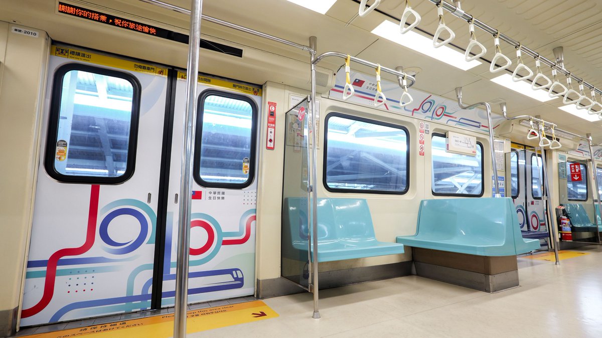 Taiwan_Today's tweet photo. A carriage with special images celebrating the upcoming National Day🎂 on Taipei Metro’s Tamsui-Xinyi Line is in service until Jan. 2, 2027. National flags🇹🇼 have also been put up at stations throughout the city as part of the celebration campaign🎉🎉🎉. (📸Taipei Metro) https://t.co/cCWKSvkyqy