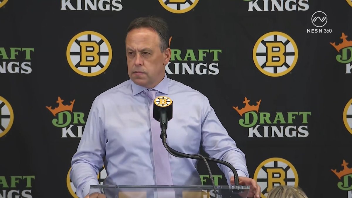 A man in a light blue dress shirt and lavender tie stands at a podium with a microphone bearing the Boston Bruins logo, speaking during a press conference against a backdrop featuring DraftKings and Bruins logos, with a NESN 360 watermark visible in the corner. The image relates to the accompanying quote, showing Boston Bruins head coach Marco Sturm addressing the media about young players James Hagens and the team's youth learning to take charge in important games.