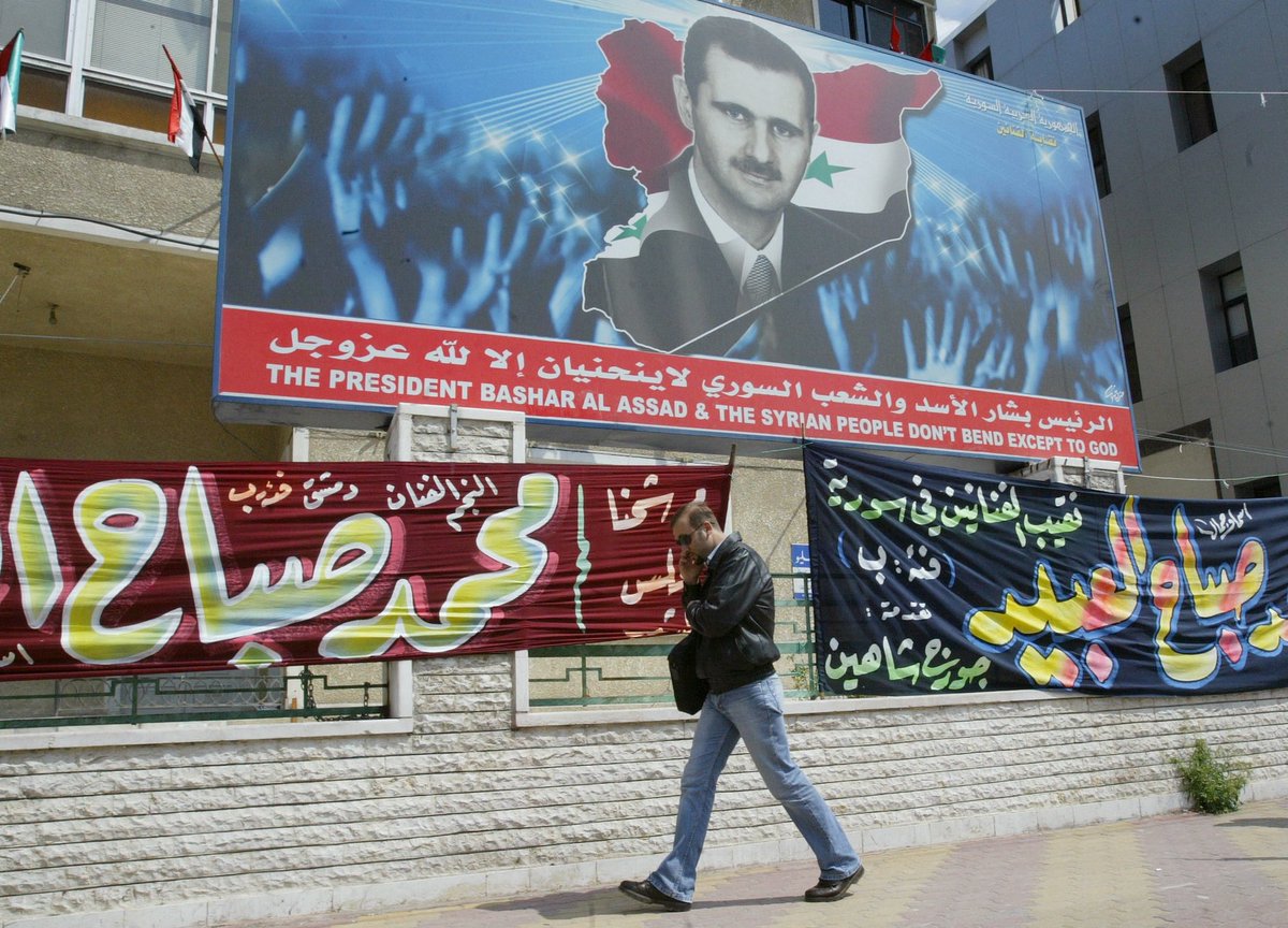 socialistassad's tweet photo. A Syrian man walks by a poster of President Assad, under which hang banners with the names of candidates for the then-upcoming parliamentary election in Damascus, 12 April 2007 https://t.co/vnyaGnQOQQ