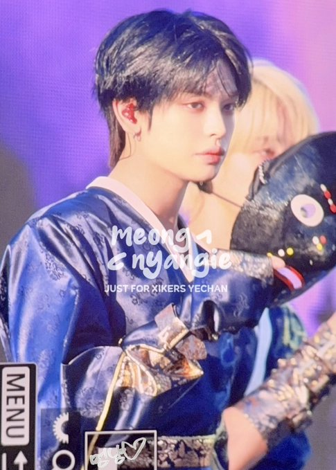 A K-pop performer in a blue traditional Korean outfit holds a dark mask, with overlaid text reading 'meong & nyangie JUST FOR XIKERS YECHAN'.